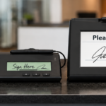 Three electronic signature pads of different sizes and screen types on a counter, from a small basic pad to a large LCD pad